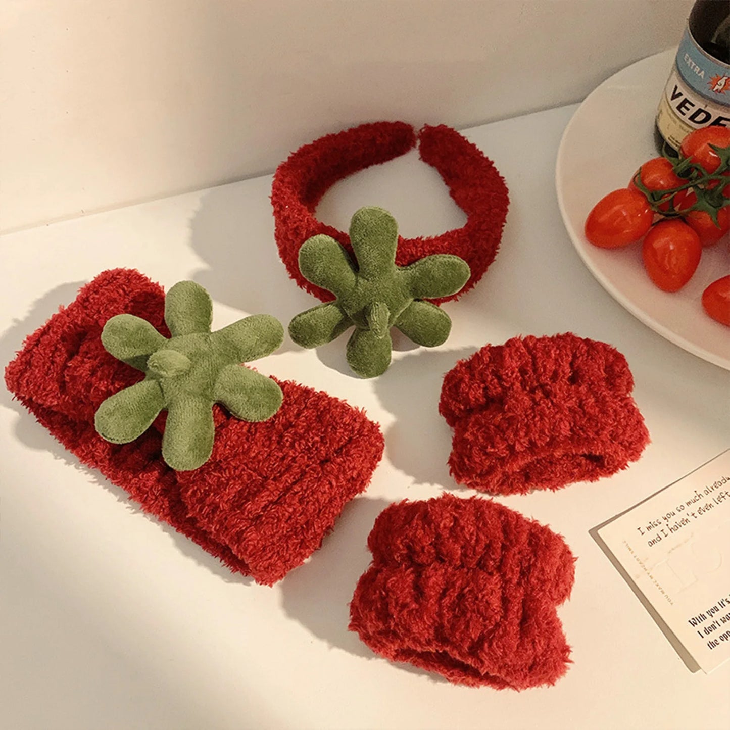 plush cat ears headband set 3pcs in red with green flower accents displayed on a table.